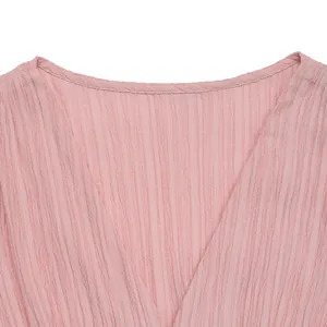 Detail of pink V-neck dress featuring unique textured seersucker fabric and neat edging