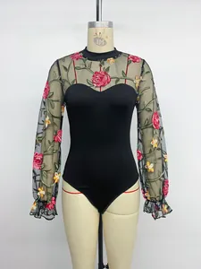 Detailed embroidery of red roses and green leaves on black mesh bodysuit sleeves