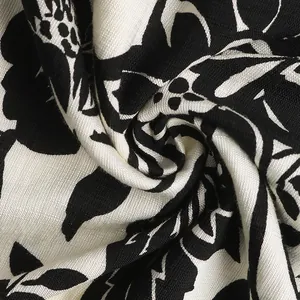 Close-up detail of soft black and white floral print fabric with premium drape and texture