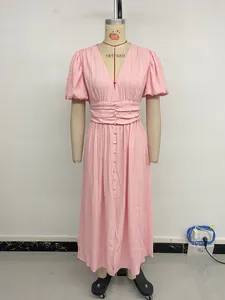 Detailed view of pink V-neck dress featuring puff sleeves and pleated waist texture