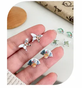 Nahaufnahme der Ohrringe im chinesischen Stil mit Schmetterling, Fächer und Tuschmalerei