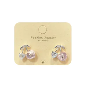 Boucles d'oreilles cerise rose avec cristal en cœur sur carte à bijoux élégante