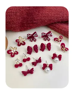 Detail of red velvet bow earrings with pearls and crystals in festive winter style