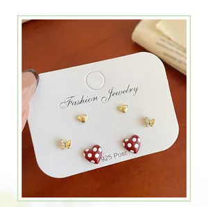 Three-pair earring set featuring 925 silver needles, hearts, and polka dot bows on wood