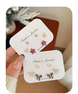 Macro view of red polka dot bow and star stud earrings set with 925 silver posts