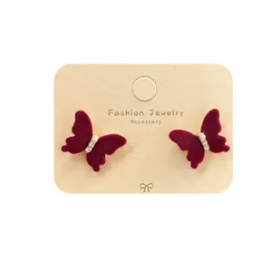 Elegant deep red flocked butterfly earrings with pearls and rhinestones on card