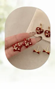 Detail of red enamel heart and star earrings with gold metal frame and sparkling rhinestones