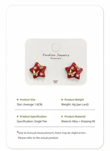 Detail view of red star-shaped enamel earrings with gold butterfly and rhinestones