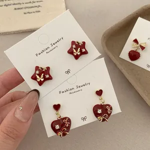 Elegant red enamel heart earrings with crystal accents and gold bow charms