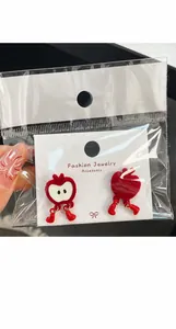 Detail of red apple heart earrings with cute legs and daily maintenance guide card