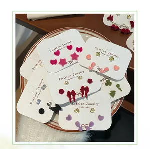 Detailed view of mixed flocked velvet bow and heart stud earrings set on a ceramic plate