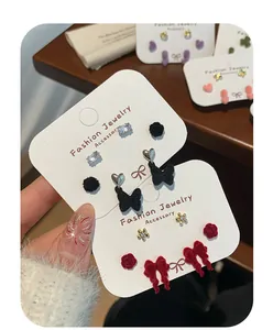 Detailed view of flocked bow and crystal stud earrings on white display card