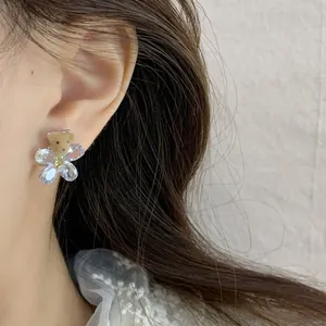 Brown flocked bear and crystal flower earrings worn by model for an elegant autumn look