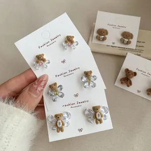 Brown flocked bear stud earrings with crystal wings and hearts in warm tones