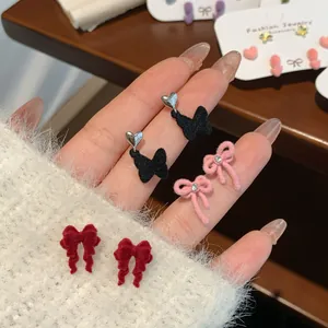 Three pairs of red and pink velvet bow stud earrings set with heart and butterfly motifs