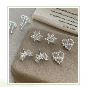 Dettaglio di set orecchini a lobo in argento a fiocco con perle su espositore elegante