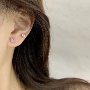 Boucles d'oreilles cœur rose en zircone avec serti à quatre griffes portées sur le lobe