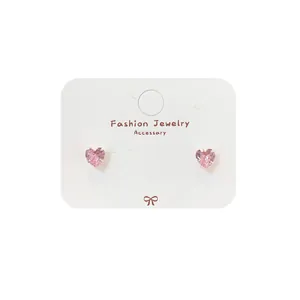 Boucles d'oreilles minimalistes en zircon rose en forme de cœur sur carte à bijoux