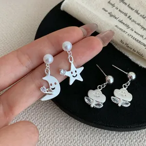 Elegante silberne Stern- und Mondohrringe mit Perlen und Kristallen auf natürlichem Grund