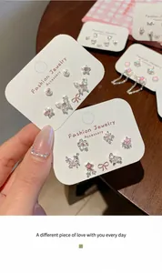 Dettaglio del set di orecchini a farfalla rosa con zirconi su cartoncino bianco
