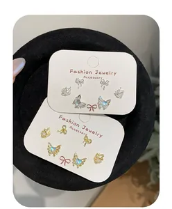 Detailed view of gold and silver butterfly stud earring set on white display card