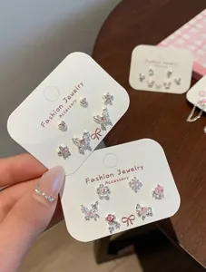 Dettaglio di orecchini a farfalla rosa con zirconi brillanti su carta per gioielli