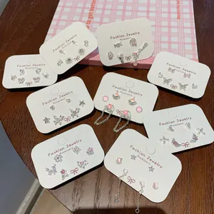 Set di orecchini a lobo con farfalla rosa, zirconi e nappe argentate su carta