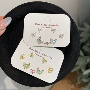 Elegant gold and silver butterfly stud earring sets on black velvet display tray