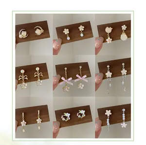 Detailed collection of pink cherry blossom earrings and pearls on wooden display cards