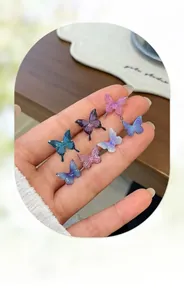 Detailed macro view of resin butterfly earring studs with colorful glitter finish