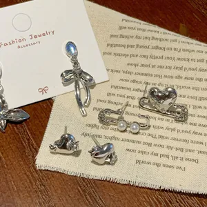 Dark aesthetic silver earrings collection with blue gems, bow tassels and heart shapes