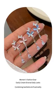Detailed macro shot of long butterfly drop earrings with pink and blue cat eye stones