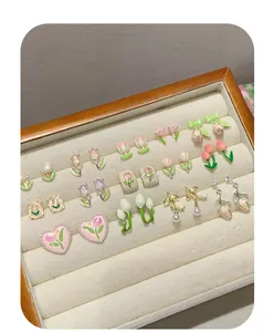 Detailed view of colorful enamel tulip earrings with pearls in a velvet jewelry box