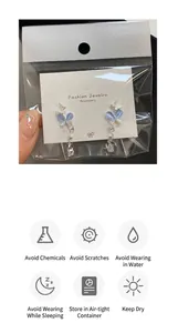 Detail view of butterfly cat eye earrings with tassels on fashion jewelry card packaging