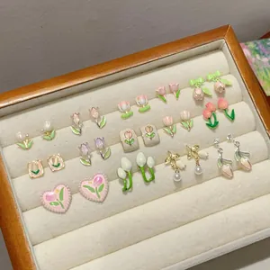 Assorted tulip flower earrings in pink and purple enamel with gold finish in a jewelry box