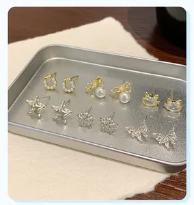 Detailed set of six small gold and silver stud earrings featuring stars and butterflies