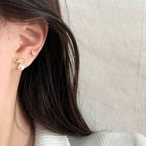 Elegant gold heart and bow pearl drop earrings set shown on a model for daily wear
