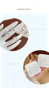 Detail shot of seven pairs of silver geometric stud earrings with blue rhinestones