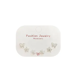 Three-pair silver earring set featuring butterfly, snowflake, and pearl flower designs