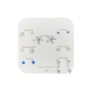 7-day silver stud earring set with blue stones and pearls on a weekly display card