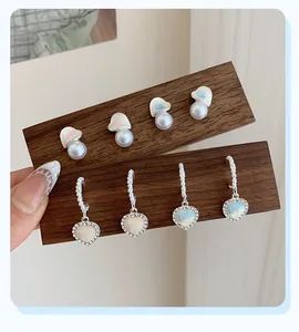 Detailed macro of heart earrings with blue dye texture, white pearls and sparkling crystals