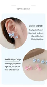 Detail showing blue fabric bow earrings with imitation pearls and zircon accents