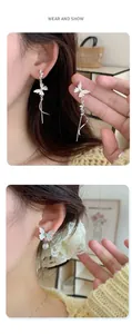 Detail showing elegant silver butterfly earrings with long tassels and pearls on model