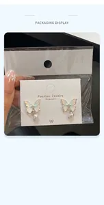 Detail of gradient butterfly earrings with round pearl pendant on fashion card