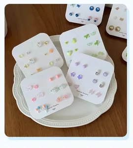 Close-up of cute mini stud earring set featuring resin bear and star shapes on a card