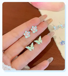 Détails de boucles d'oreilles fleurs et papillons avec émail pastel et perles douces