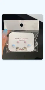 Three-pair cartoon earring set featuring stars and cute girl icons in clear retail packaging