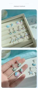 Detail of ocean-themed earrings featuring iridescent starfish, seashells and pearls