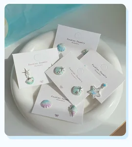 Detailed macro view of marine ocean earrings set with zircon, shells and starfish elements