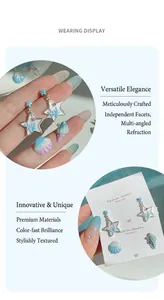 Detail of star and seashell earrings with blue coral motifs and pearlescent finish